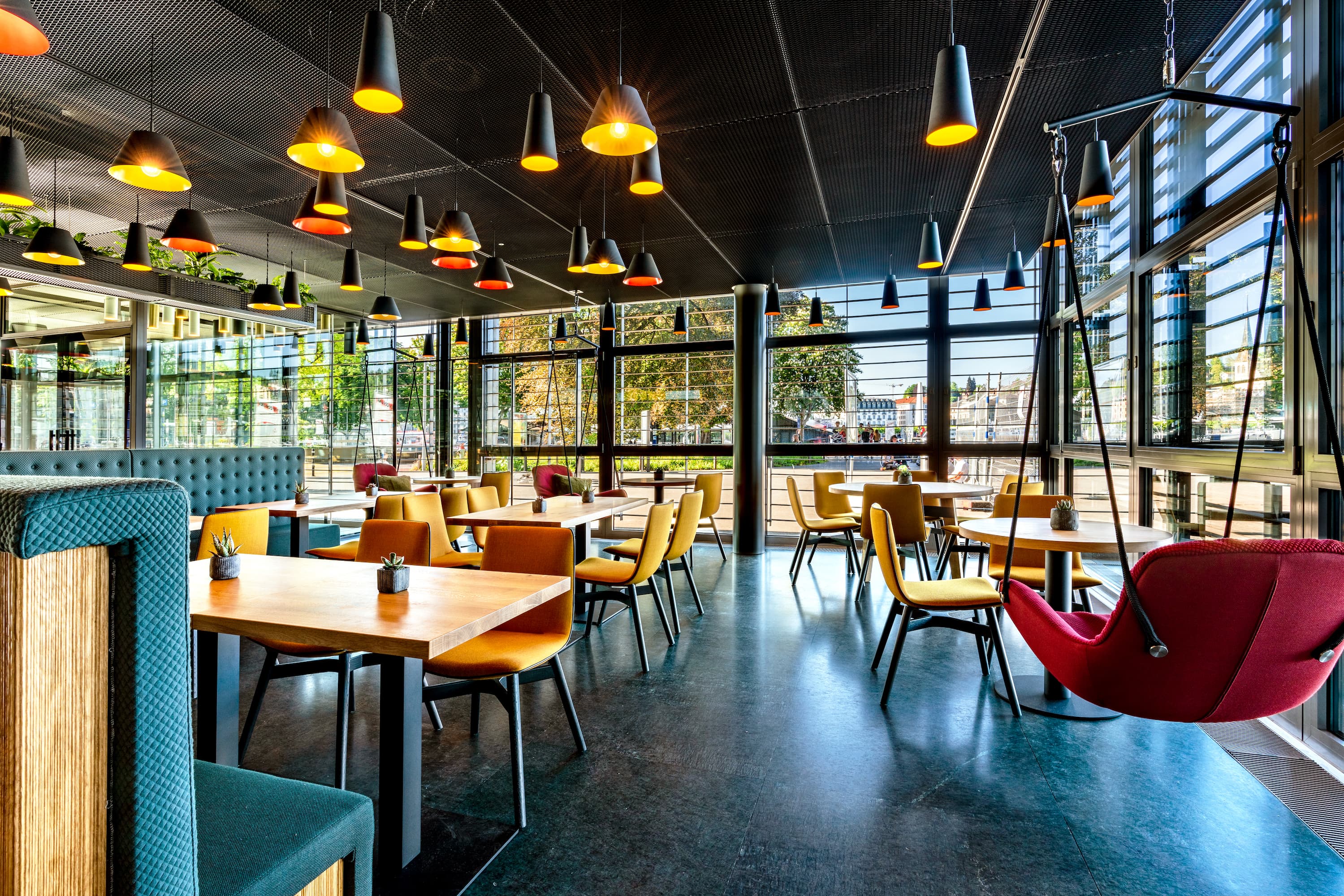 Tables and Hanging Chairs in the Deli Cafénbar Le Piaf in the KKL Lucerne with a View of the Europaplatz